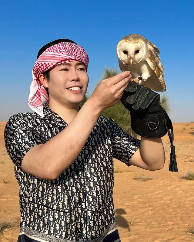 Luke Lee holding a barn owl in the desert